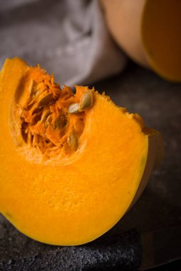 Koyu arka planda çiğ balkabağı, karanlık ruh hali tarzı.