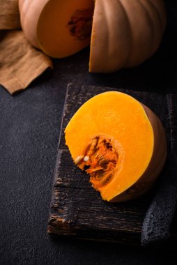 Koyu arka planda çiğ balkabağı, karanlık ruh hali tarzı.