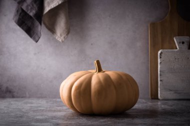 Koyu arka planda çiğ balkabağı, karanlık ruh hali tarzı.