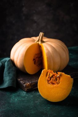 Yeşil arka planda çiğ balkabağı, karanlık ruh hali tarzı.