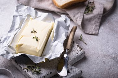 Gri arka planda taze tereyağı. Süt ürünü.