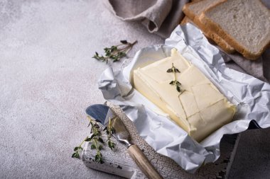 Gri arka planda taze tereyağı. Süt ürünü.