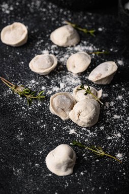 Çiğ mantı ya da siyah arka planda etli ravioli.