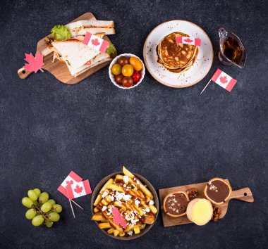 Kanada Günü geleneksel gıda konsepti. Poutine, tereyağlı tart, sandviç, akçaağaç şuruplu Kanada gözlemesi.