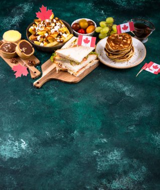 Kanada Günü geleneksel gıda konsepti. Poutine, tereyağlı tart, sandviç, akçaağaç şuruplu Kanada gözlemesi.