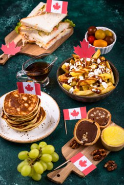 Kanada Günü geleneksel gıda konsepti. Poutine, tereyağlı tart, sandviç, akçaağaç şuruplu Kanada gözlemesi.