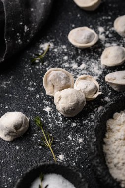 Çiğ mantı ya da siyah arka planda etli ravioli.