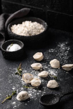 Çiğ mantı ya da siyah arka planda etli ravioli.