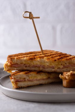 Kızarmış ekmek ya da jambonlu sandviç ve erimiş peynir.