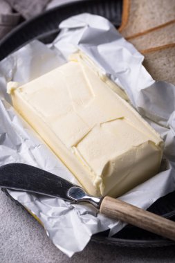 Gri arka planda taze tereyağı. Süt ürünü.