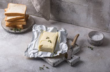 Gri arka planda taze tereyağı. Süt ürünü.