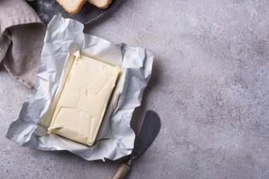 Gri arka planda taze tereyağı. Süt ürünü.