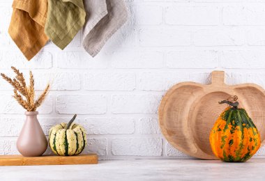 Mutfak tezgahının üstünde kavanozlar ve beyaz arka planda kesim tahtaları var.