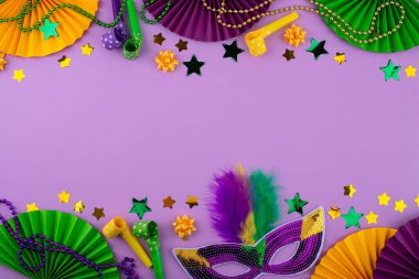 Mardi Gras arka planında mor, altın ve yeşil süslemeler, boncuklar ve karnaval maskesi var.