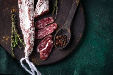 Yeşil arka planda baharatlı salam sosisi.