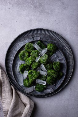 Donmuş ıspanak yeşil küpleri buzlu metal kasede