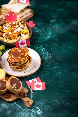 Kanada Günü geleneksel gıda konsepti. Poutine, tereyağlı tart, sandviç, akçaağaç şuruplu Kanada gözlemesi.