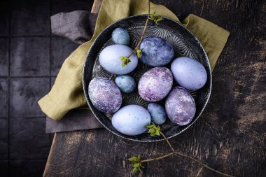 Mor ve mavi renkli amberçiçeği çayıyla boyanmış Paskalya yumurtaları.