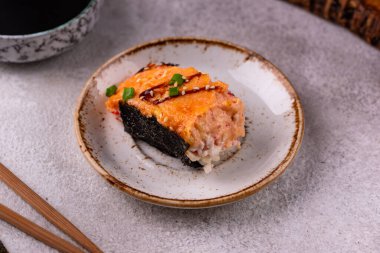 Tembel suşi ya da somon ve yengeç surimi çubuklu fırında suşi.