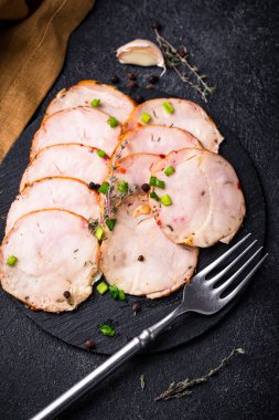 Tabağında bitkiler olan dilimlenmiş tavuk sosisi.