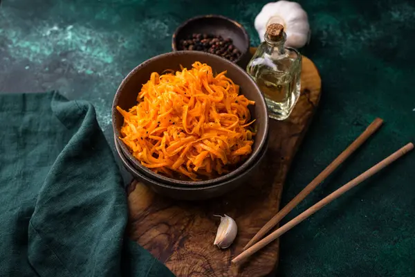 Yeşil arka planda baharatlı Kore havuç salatası.