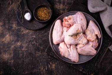 Siyah arka planda çiğ tavuk kanadı..