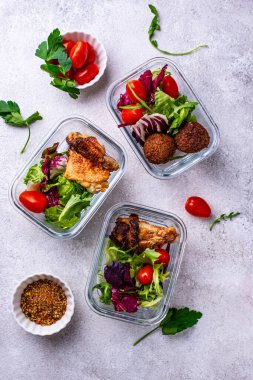 Yemek hazırlama konsepti. Konteynırda sağlıklı yiyecekler. Tavuk ve falafel soslu salata