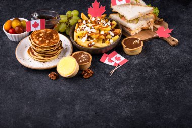 Kanada Günü geleneksel gıda konsepti. Poutine, tereyağlı tart, sandviç, akçaağaç şuruplu Kanada gözlemesi.