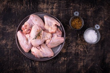 Siyah arka planda çiğ tavuk kanadı..