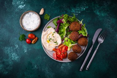 Humus, falafel ve sebzeli sağlıklı vejetaryen salatası.