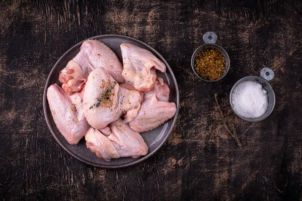 Siyah arka planda çiğ tavuk kanadı..