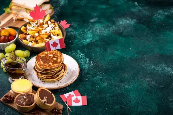 Kanada Günü geleneksel gıda konsepti. Poutine, tereyağlı tart, sandviç, akçaağaç şuruplu Kanada gözlemesi.