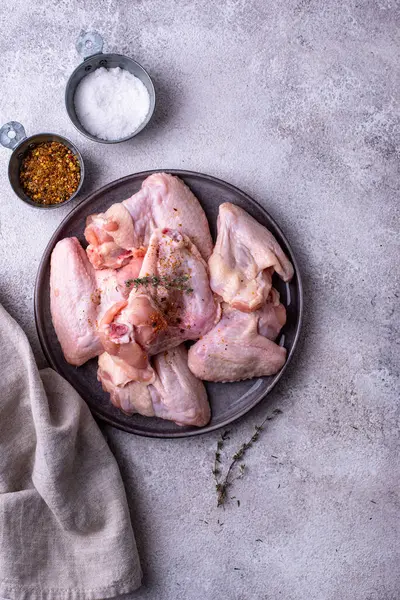 Gri arka planda çiğ tavuk kanadı..