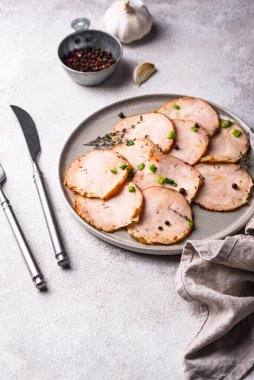 Tabağında bitkiler olan dilimlenmiş tavuk sosisi.