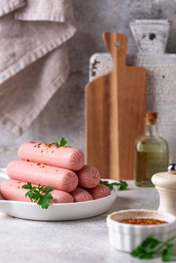 Arka planda baharatlı haşlanmış domuz sosisi.