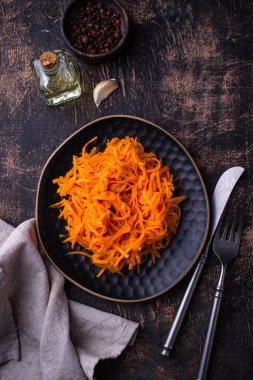 Siyah arka planda baharatlı Kore havuç salatası.