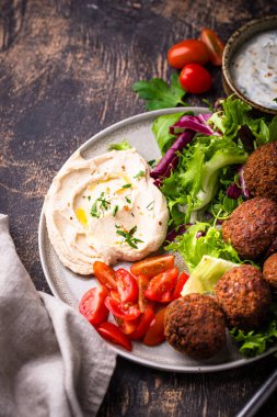 Humus, falafel ve sebzeli sağlıklı vejetaryen salatası.