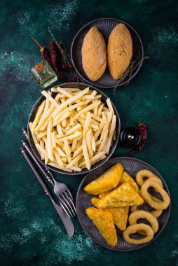 Donmuş gıda çeşitleri. Patates kızartması, patates kızartması, pirzola ve soğan halkası.