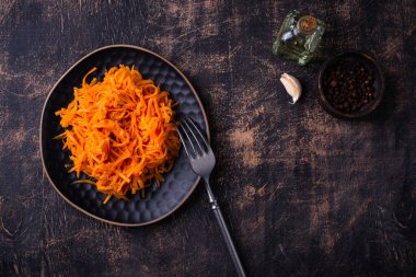 Siyah arka planda baharatlı Kore havuç salatası.