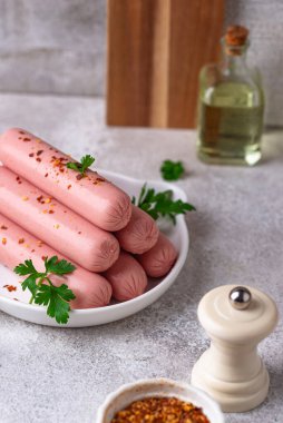 Arka planda baharatlı haşlanmış domuz sosisi.