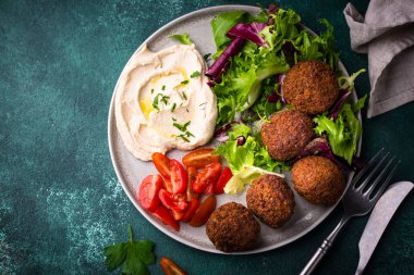 Humus, falafel ve sebzeli sağlıklı vejetaryen salatası.
