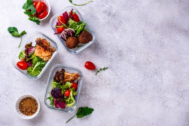Yemek hazırlama konsepti. Konteynırda sağlıklı yiyecekler. Tavuk ve falafel soslu salata