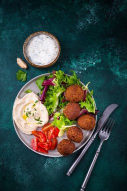Humus, falafel ve sebzeli sağlıklı vejetaryen salatası.