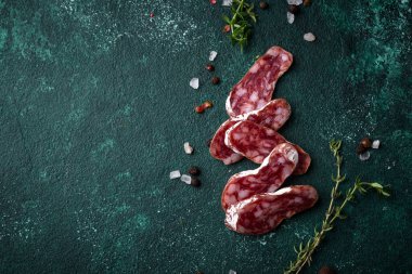 Yeşil arka planda baharatlı salam sosisi.