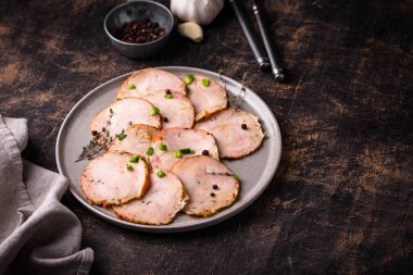 Tabağında bitkiler olan dilimlenmiş tavuk sosisi.