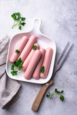 Arka planda baharatlı haşlanmış domuz sosisi.