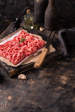 Koyu arkaplanda baharatlı çiğ et.