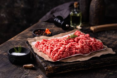 Koyu arkaplanda baharatlı çiğ et.