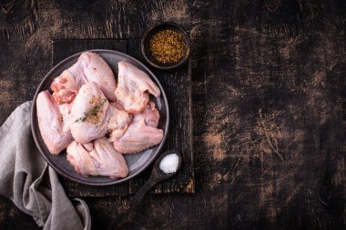 Siyah arka planda çiğ tavuk kanadı..