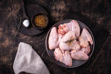 Siyah arka planda çiğ tavuk kanadı..